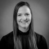 Black and white headshot of woman with long hair in black shirt.