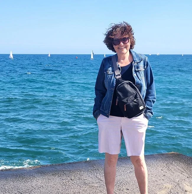 Jennifer-Lee Thomas, directrice nationale des communications et de la philanthropie à CPAWS, debout au bord de l'eau avec des voiliers en arrière-plan