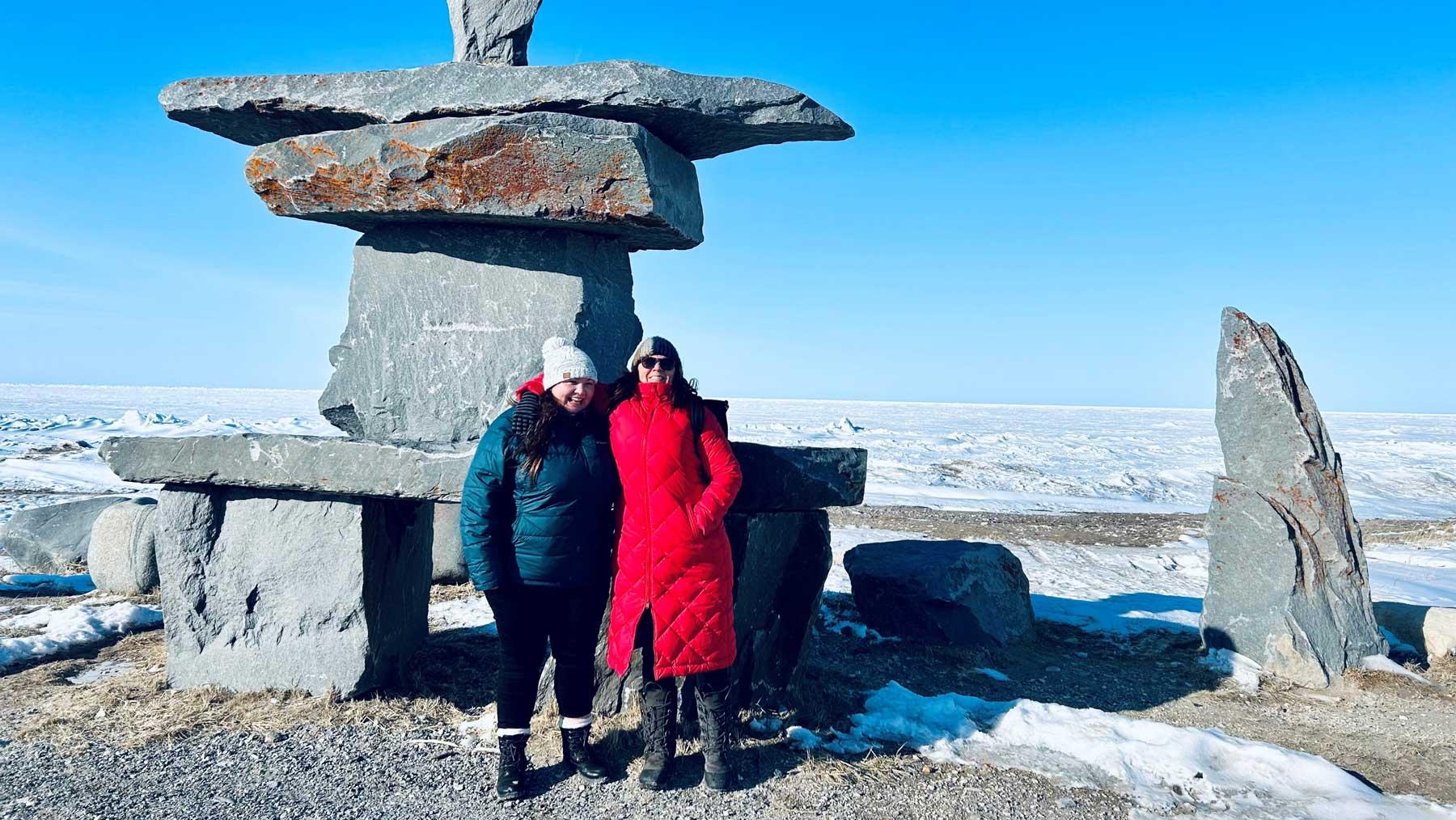 Natalie Groulx and Alex Barron side by side on the shore of the frozen Hudson Bay