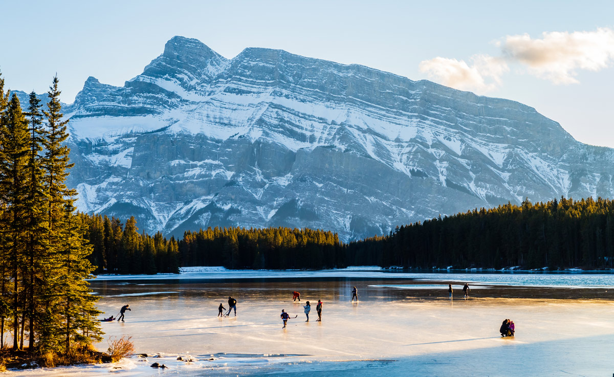 People in the distance skating on a frozen lake.