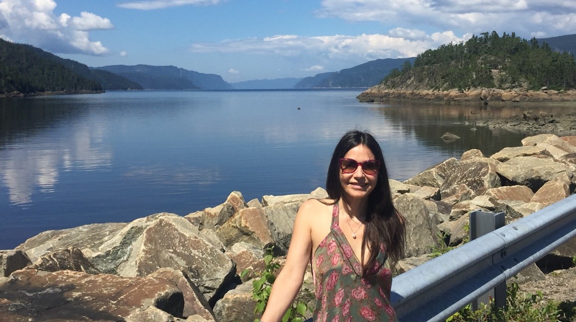 Photo of Johanne Rioux standind in front of a lac