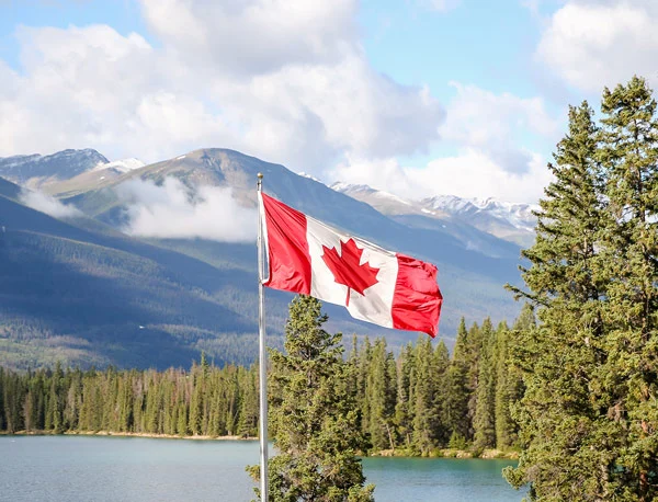 Canadian flag with the Rockies in the background