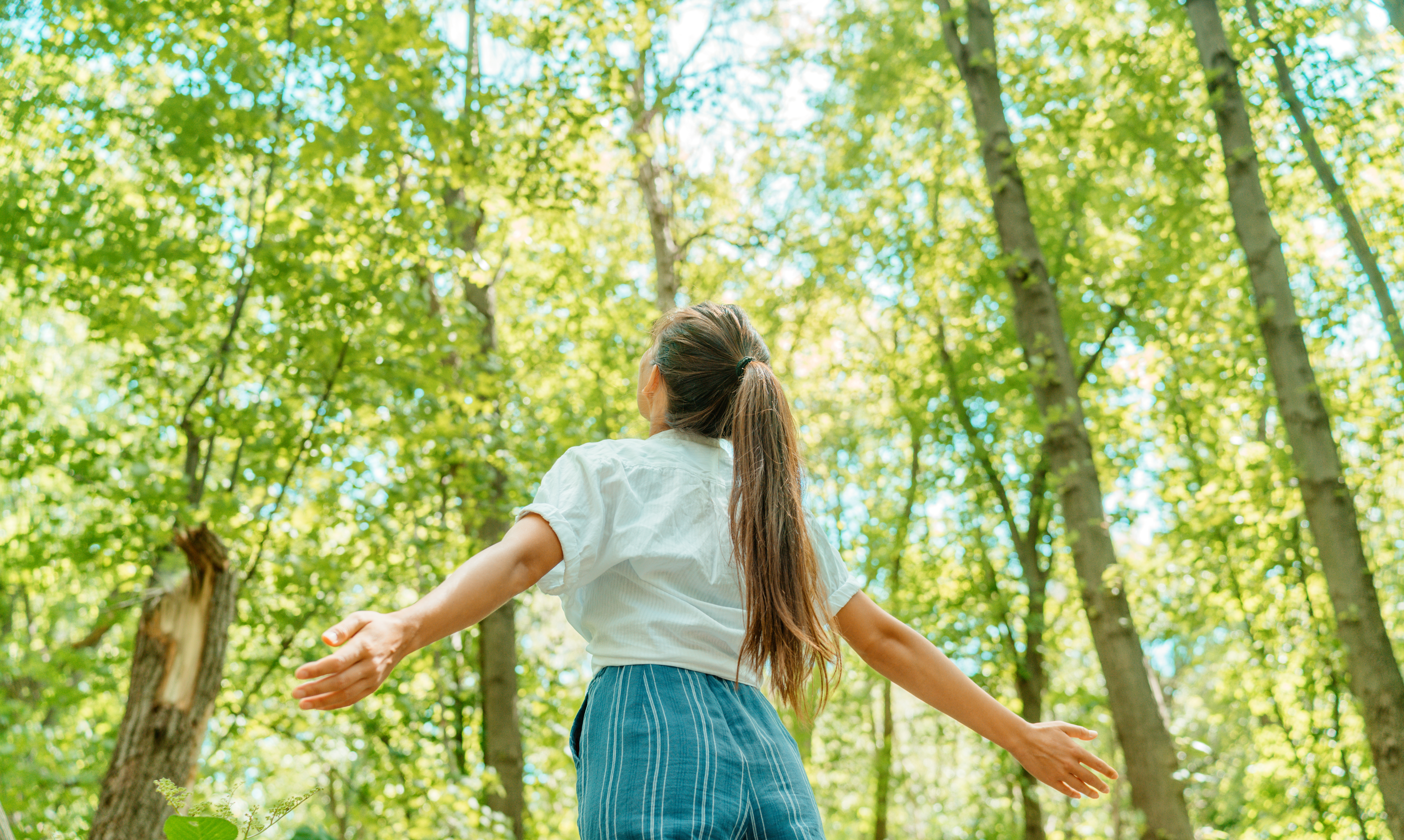Woman breathing clean air in nature forest.